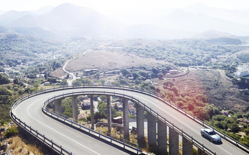 Car on winding mountain bridge