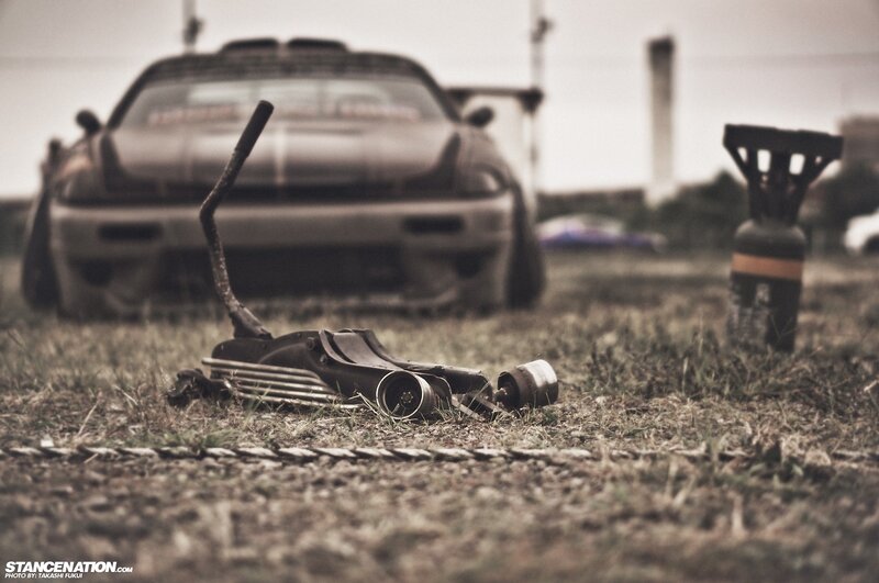 Car parts on grass with car in background