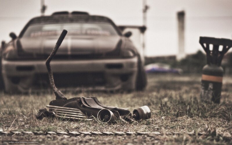 Car parts on grass with car in background