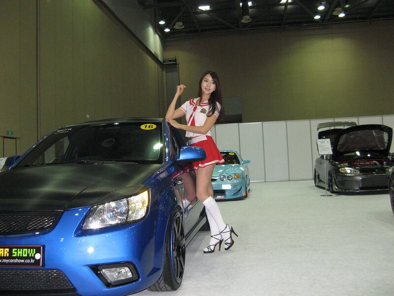 Car show model posing with blue car