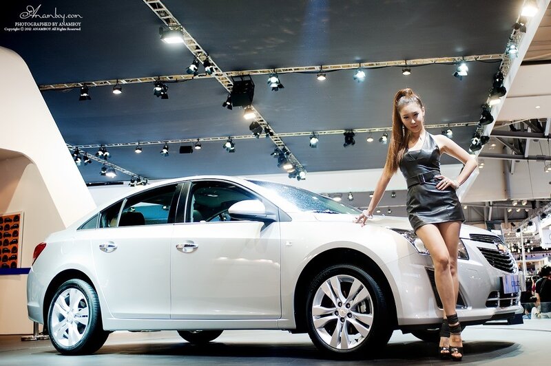 Car show model posing with sedan