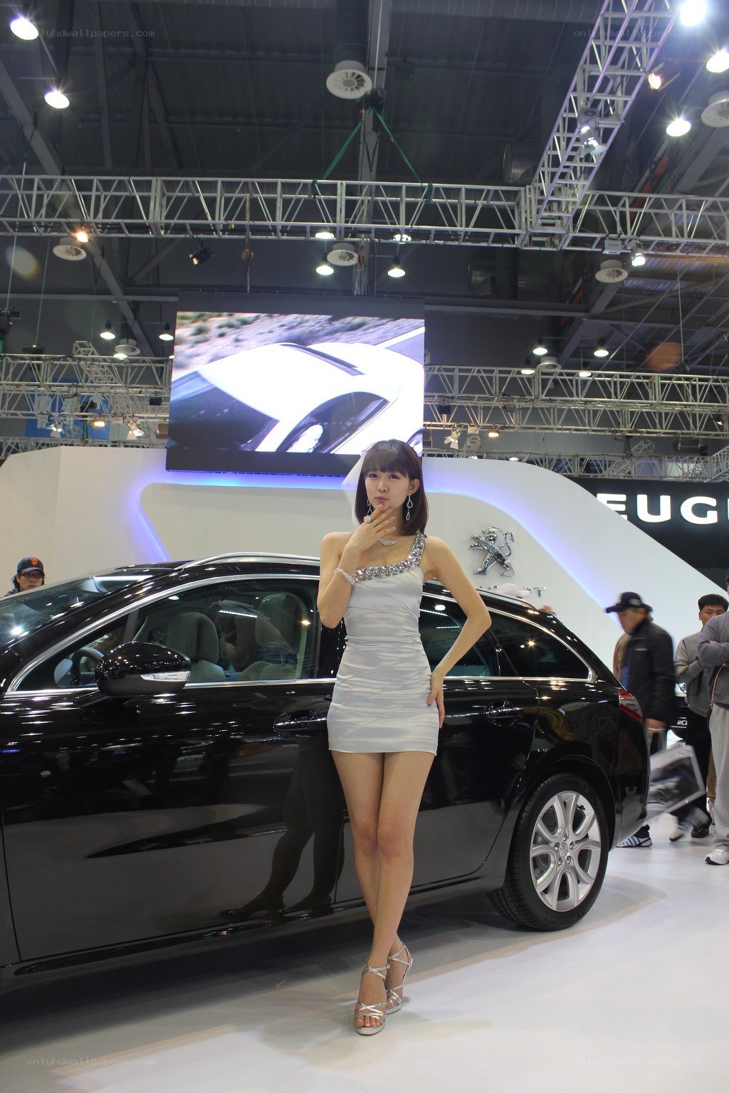 Car show model posing with sedan