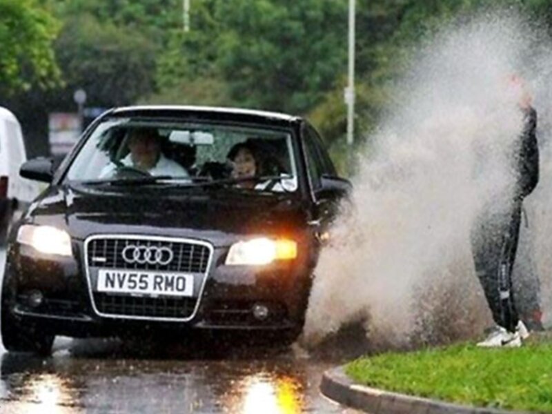 Car splashing water on pedestrian