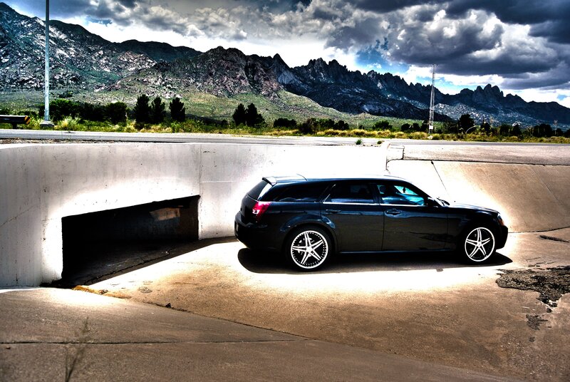 Car under overpass with mountains