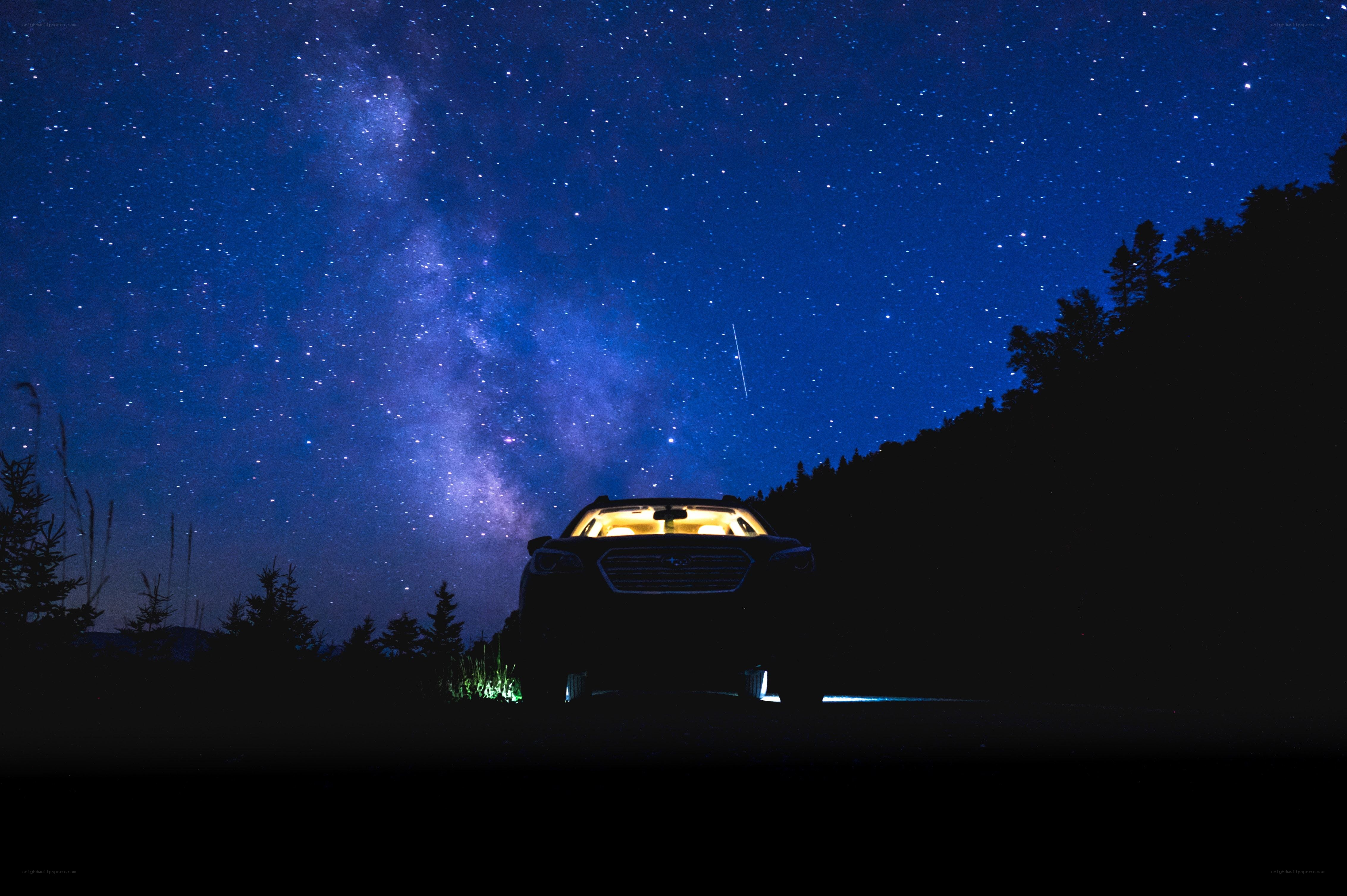 Car under starry night sky