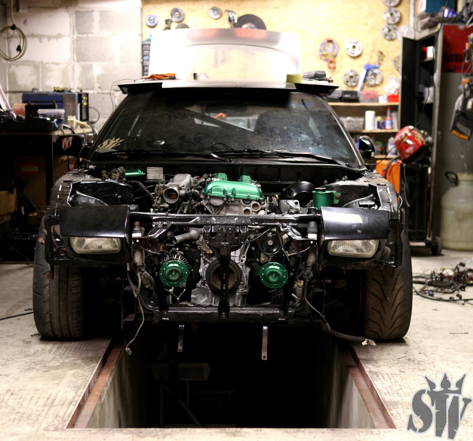 Car with exposed engine in garage