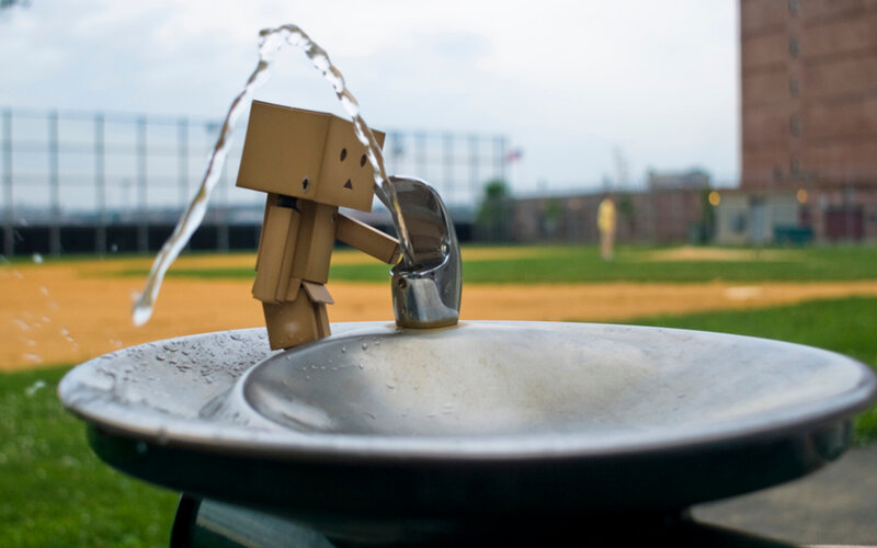 Cardboard Figure at Water Fountain — Brown