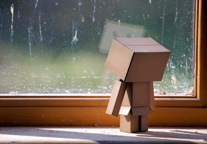 Cardboard figure by window