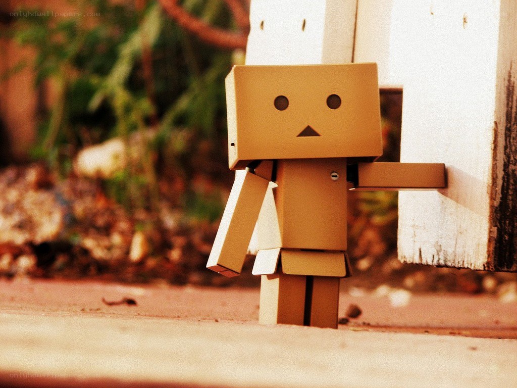 Cardboard robot by a fence