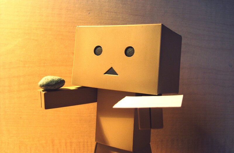 cardboard robot holding a stone
