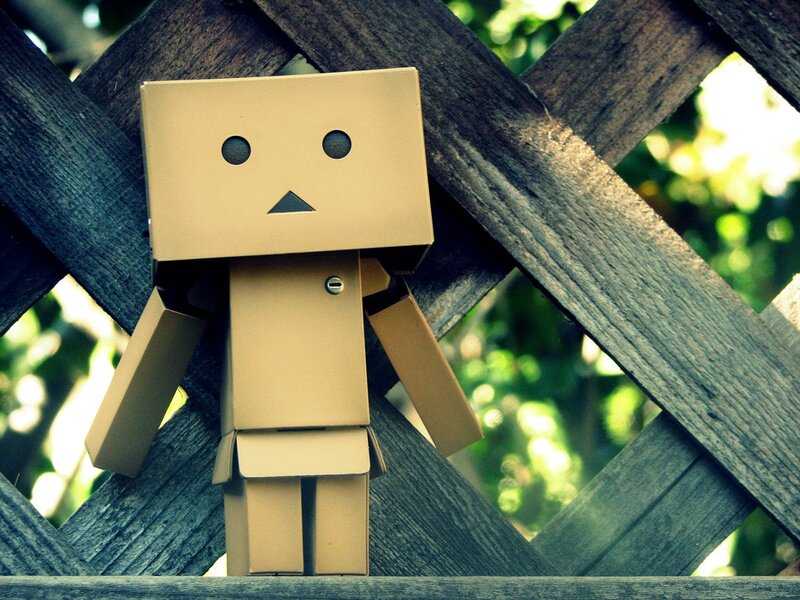 Cardboard robot on wooden fence