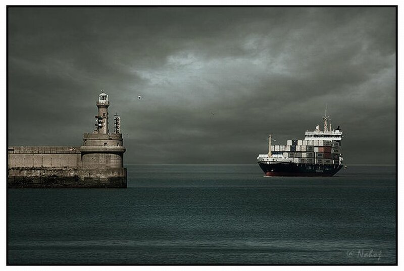 Cargo ship near lighthouse