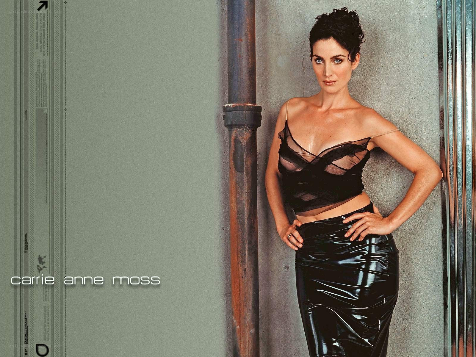 Carrie Anne Moss posing in black