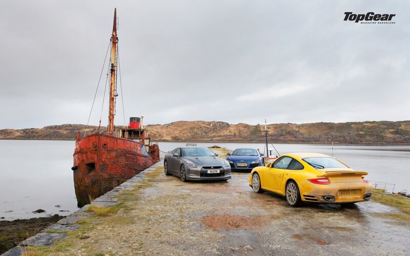 Cars at a dock with a shipwreck