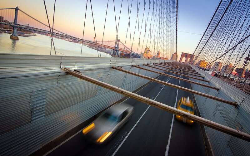 Cars on a suspension bridge at sunset