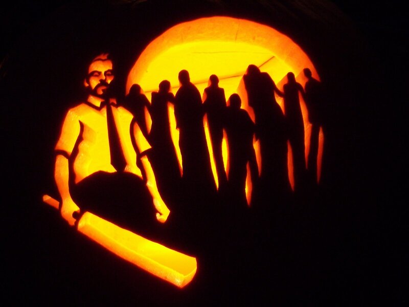 carved pumpkin with man and crowd