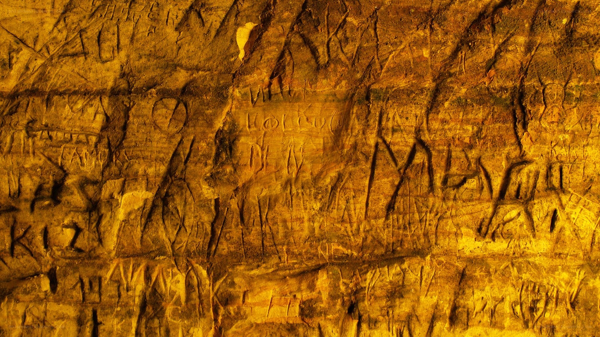 carved rock wall with graffiti