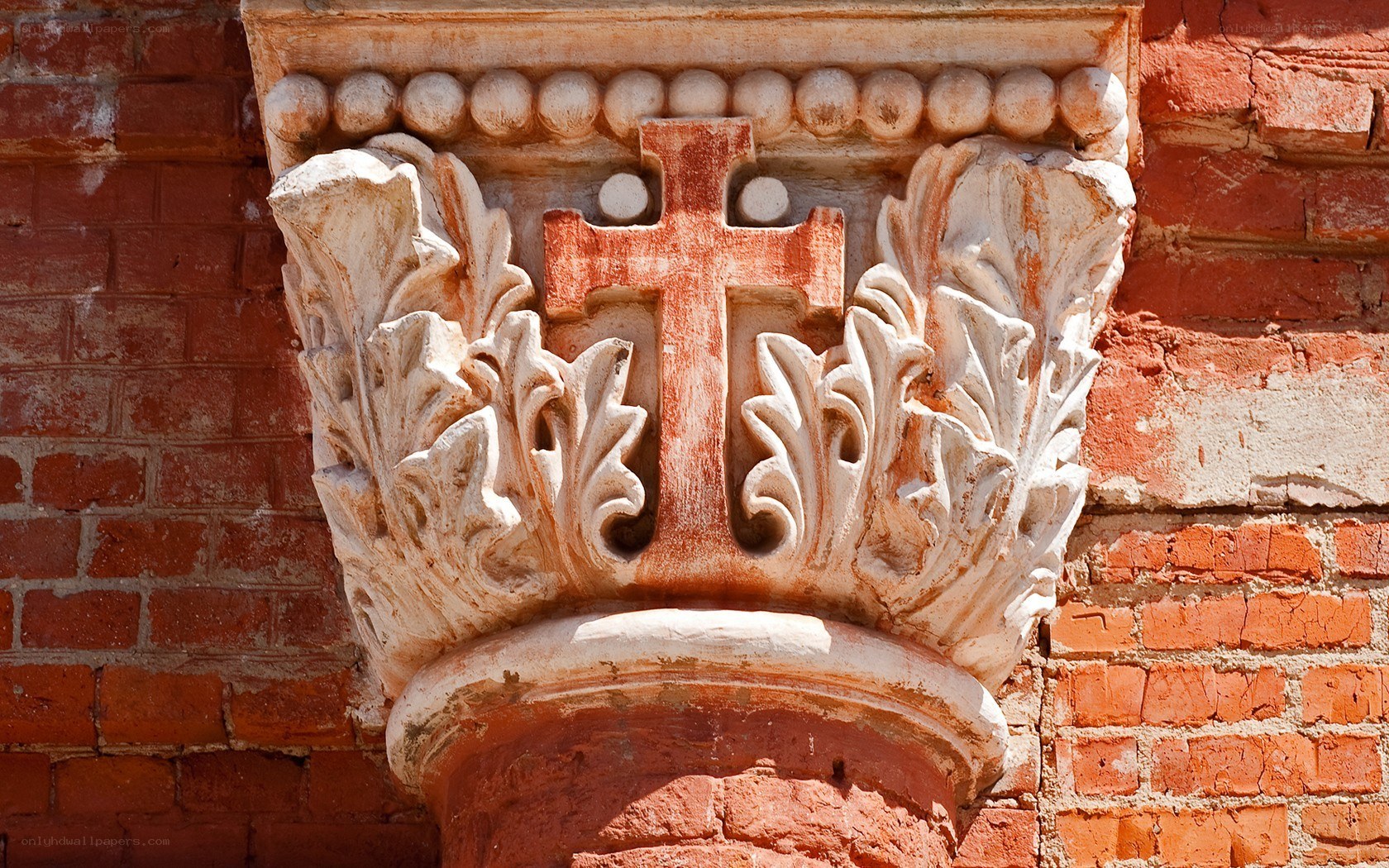 Carved stone capital with cross