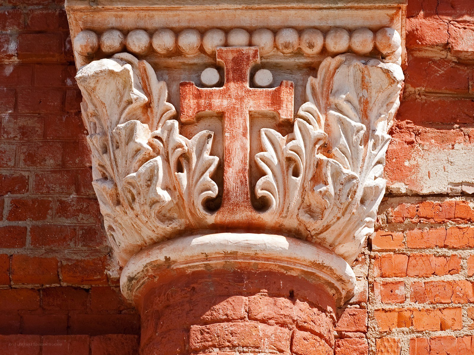 Carved stone capital with cross
