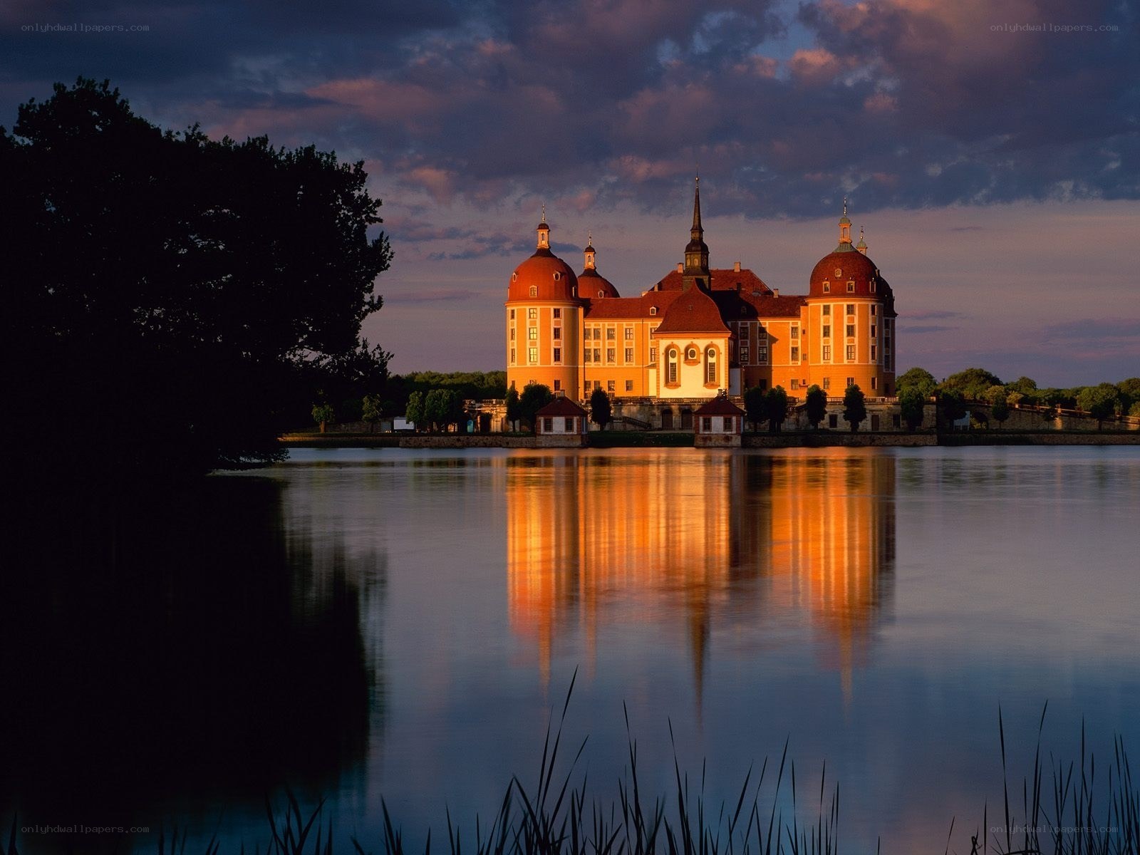 Castle at dusk reflected in water