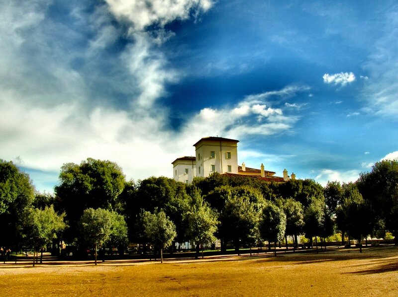 Castle behind trees under blue sky