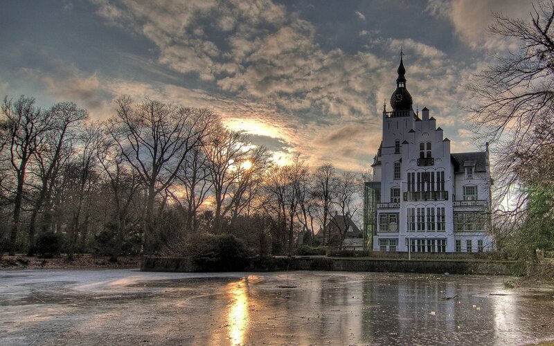 Castle by a frozen pond at sunset