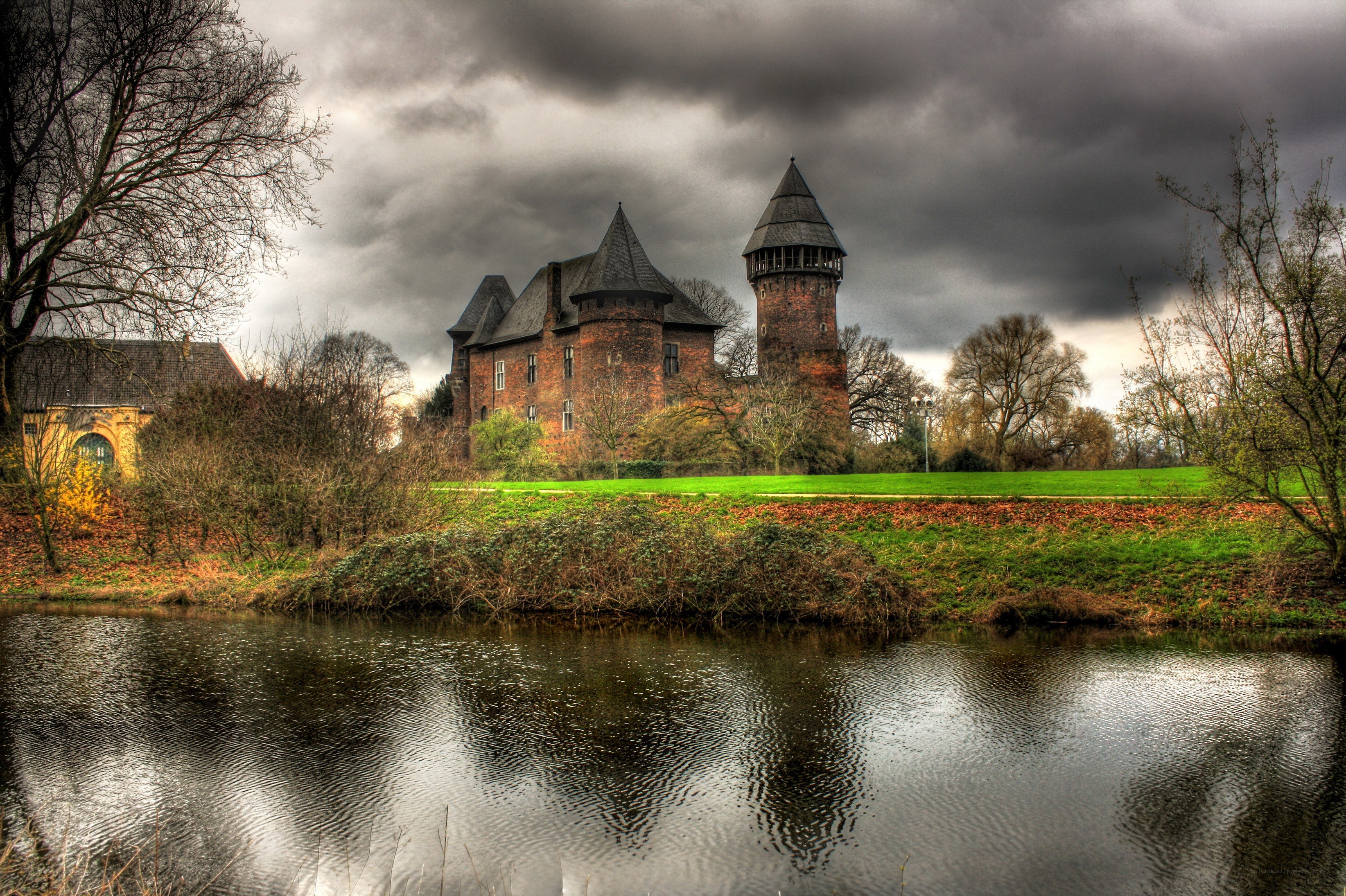 Castle by the river under stormy sky