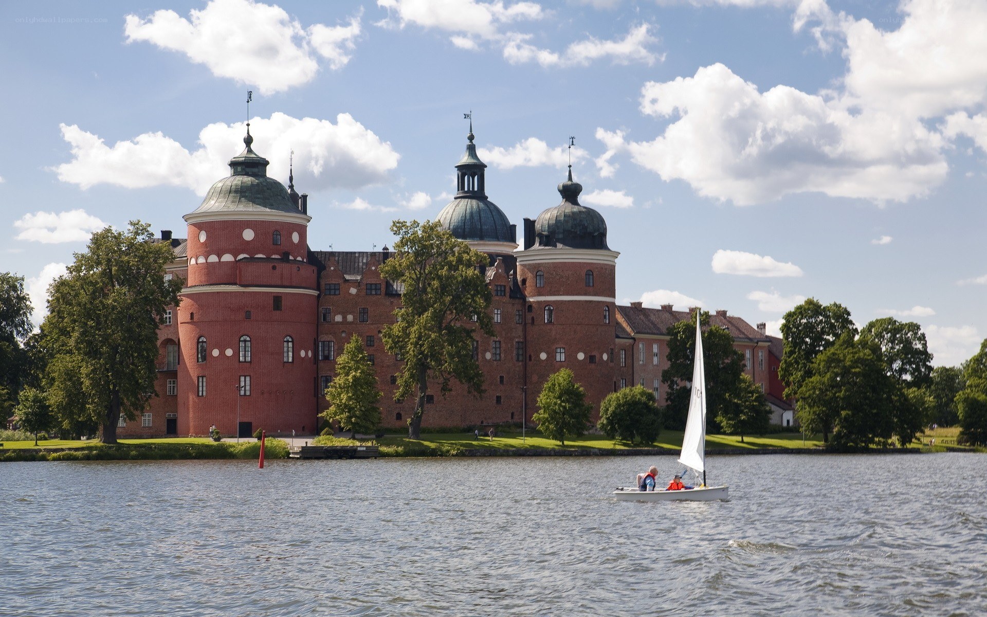 castle by the water with sailboat