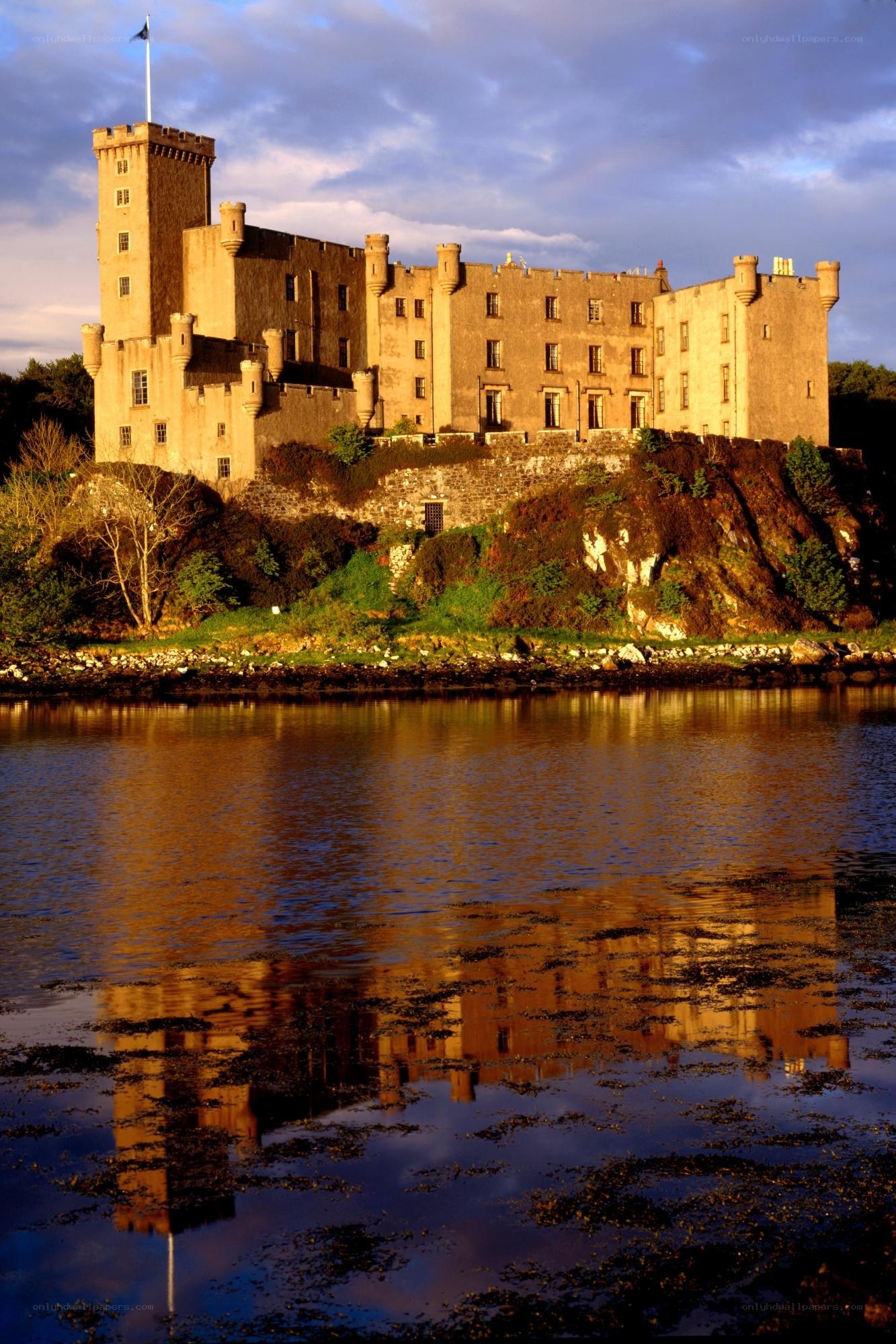 Castle on a riverbank at sunset
