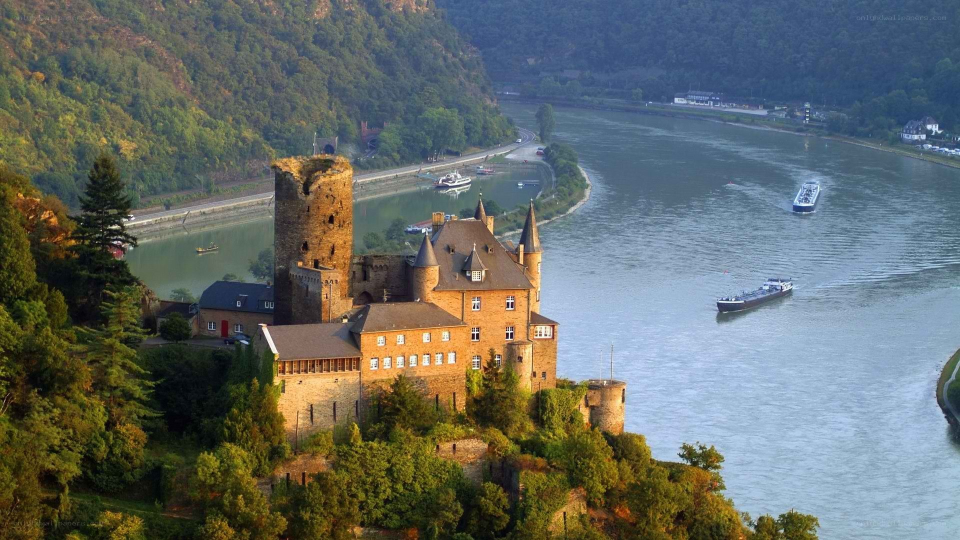 castle on riverbank with boats