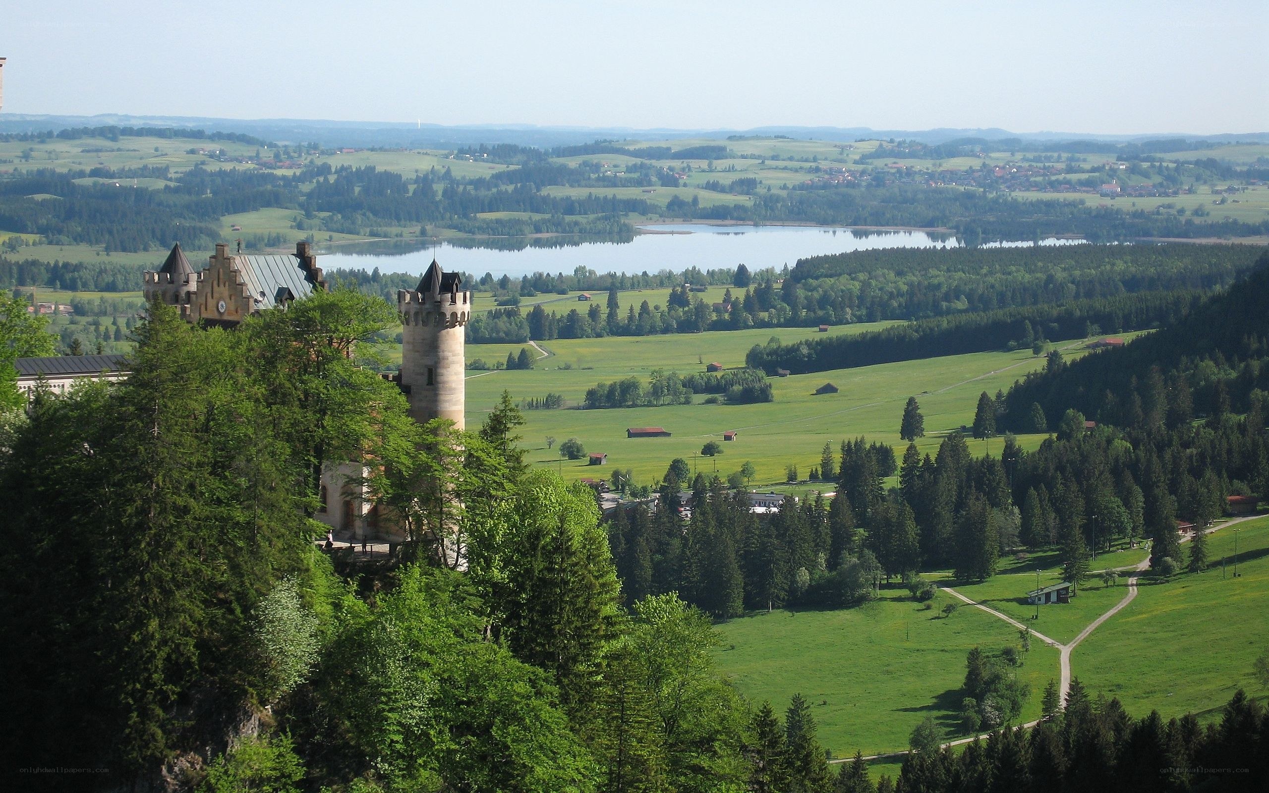Castle overlooking a lake and green fields