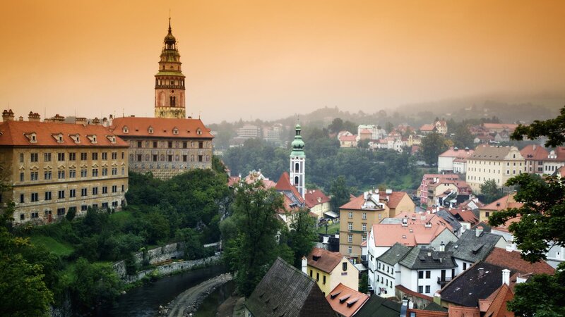 Castle overlooking a town at sunrise