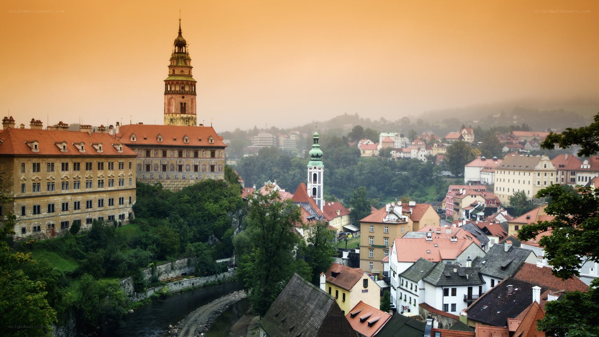 Castle overlooking a town at sunrise
