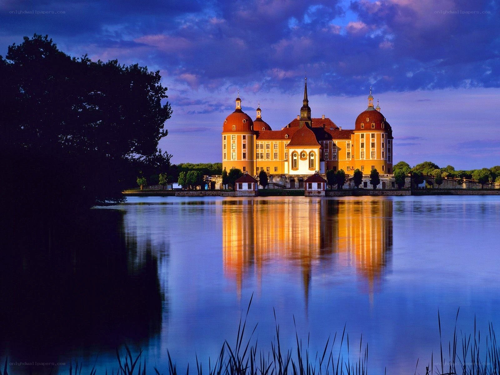 castle reflected in lake at dusk