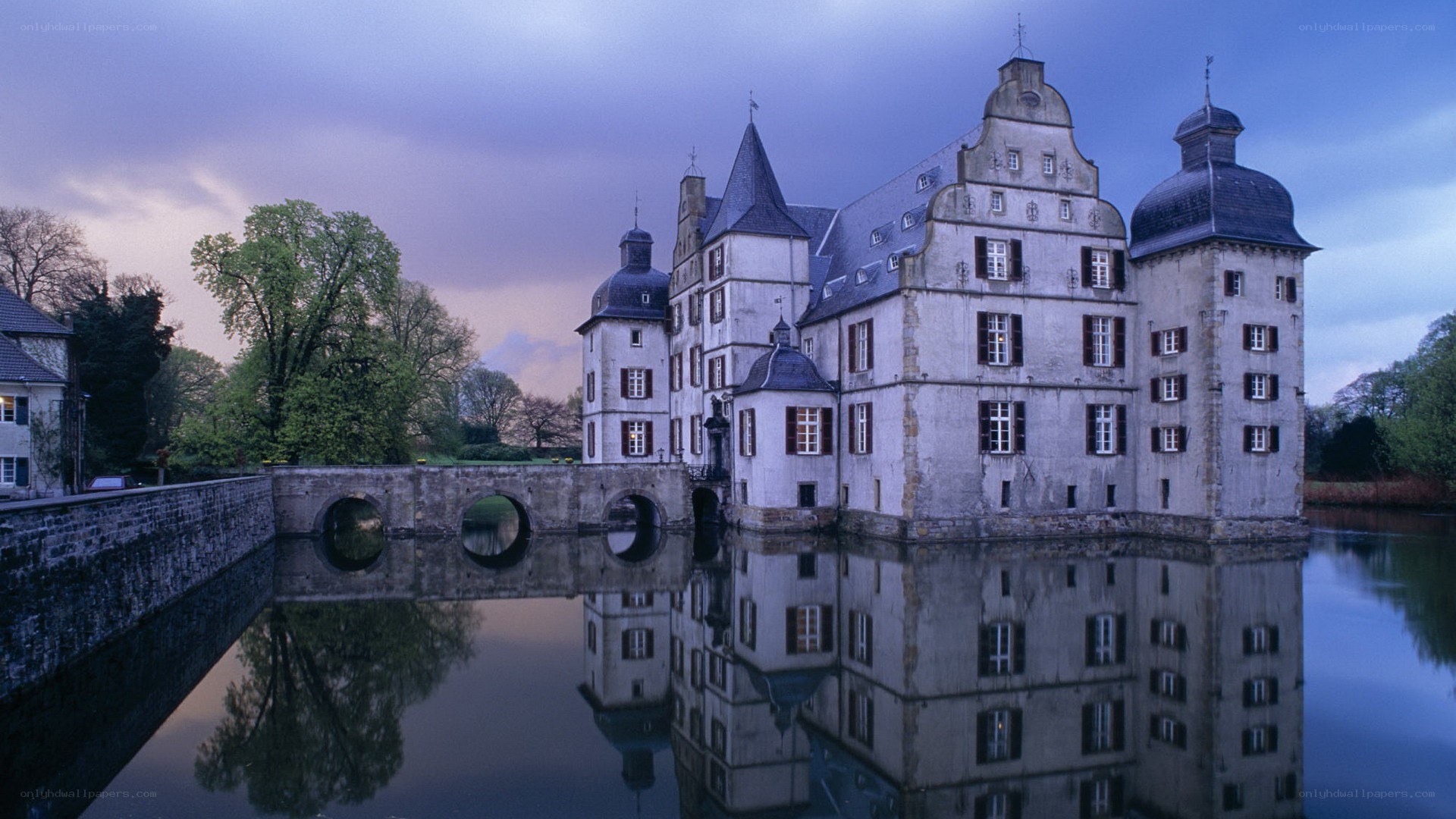 castle reflected in water at dusk