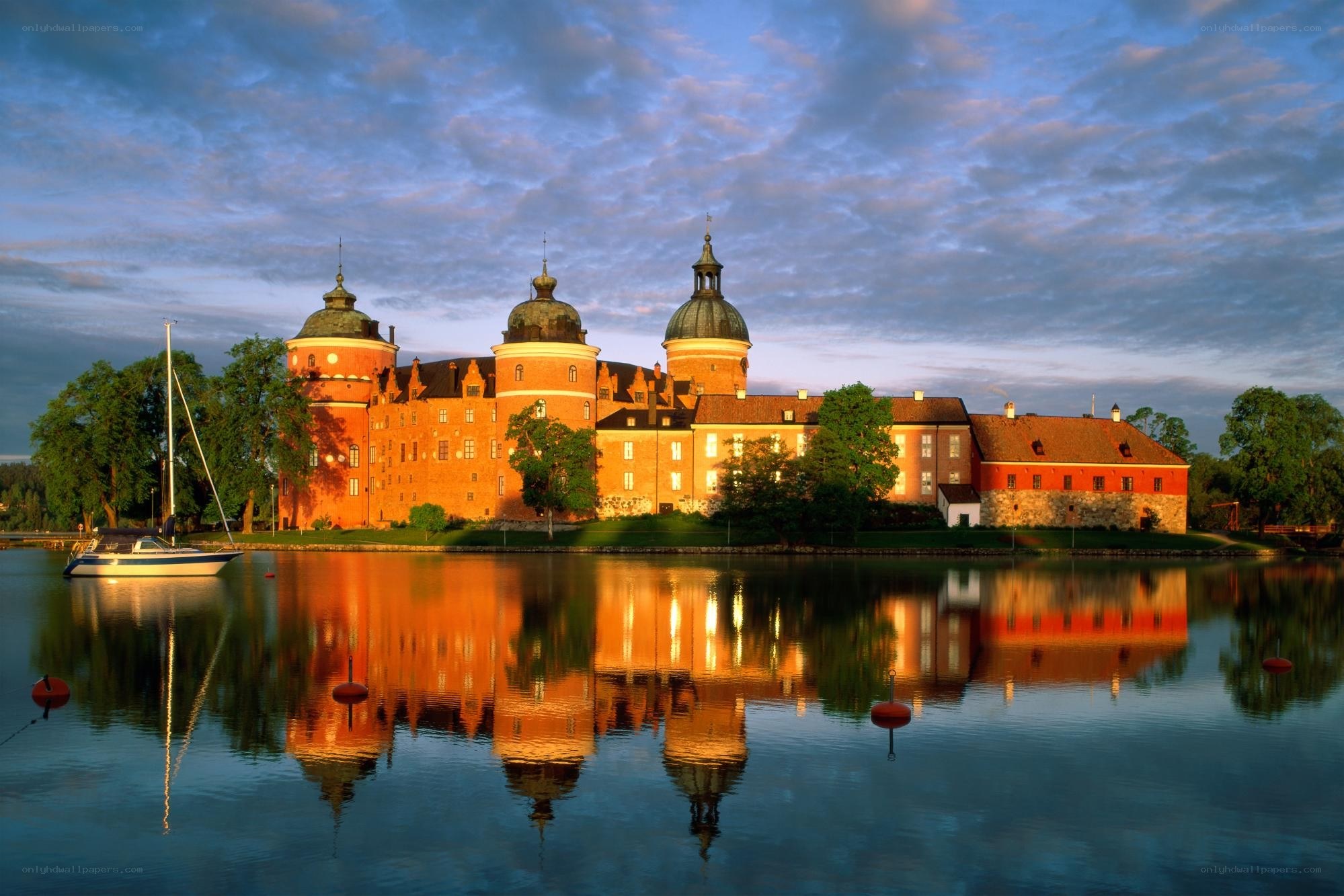 castle reflected in water at sunset