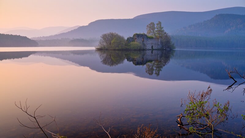 Castle ruin on a lake at dawn