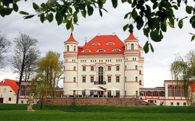 castle with red roof and green lawn
