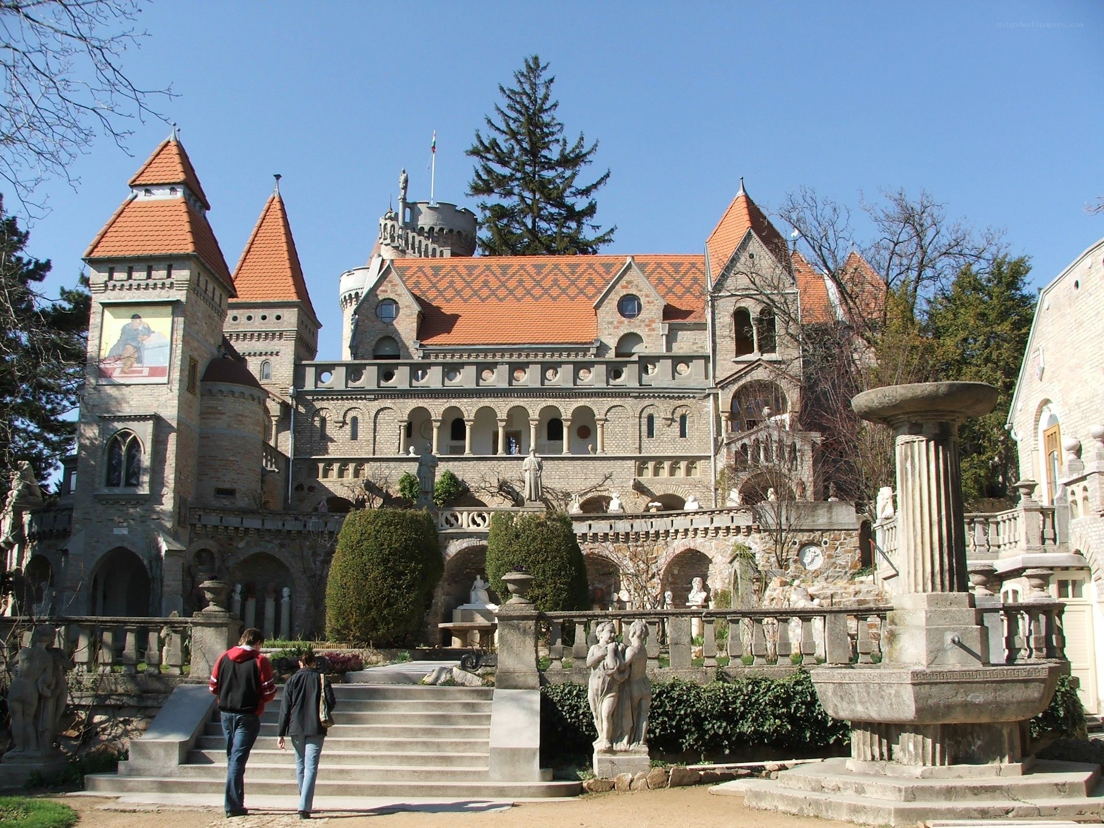 castle with red roof and statues