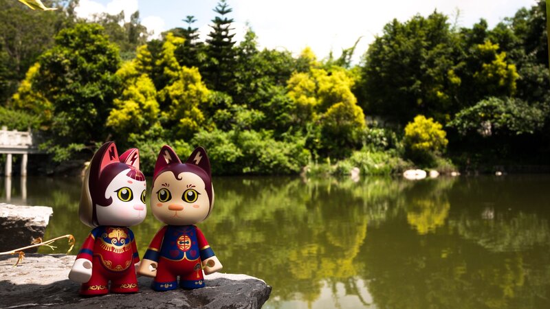 Cat figurines by a pond