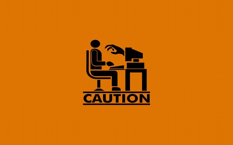 caution sign with person at computer
