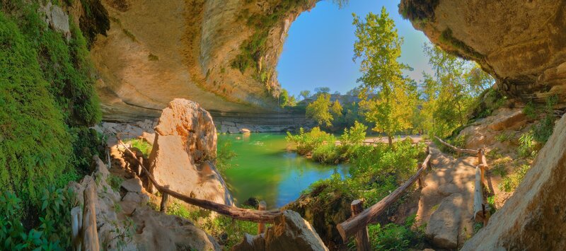 Cave entrance to a green river