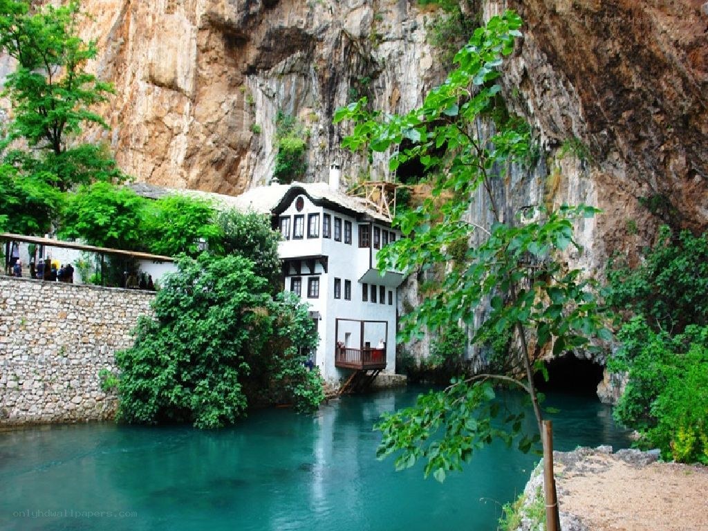 Cave house by a turquoise river