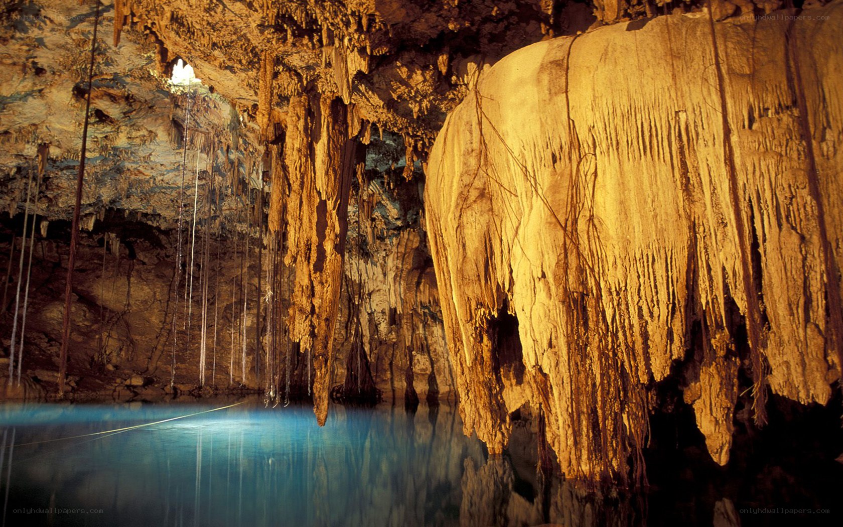 Cave with stalactites and blue water