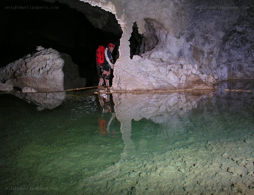Caver in a cave with water