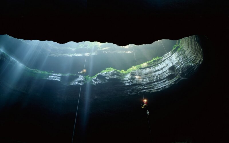 Cavers exploring a deep cave
