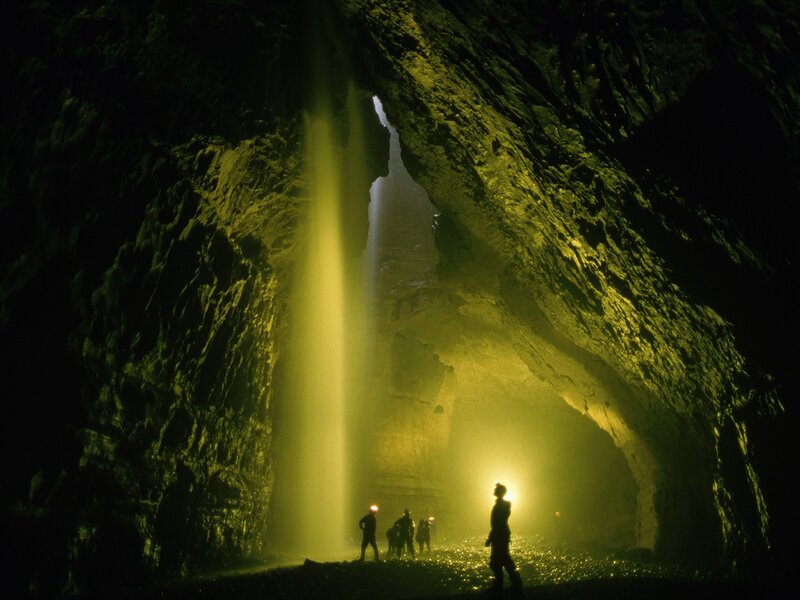 Cavers in a cave with waterfall