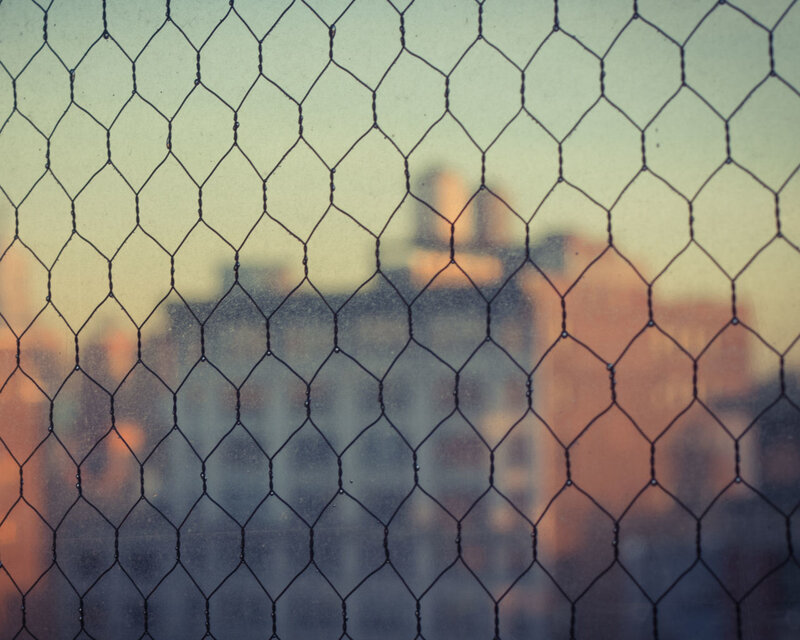 chain-link fence with blurred cityscape