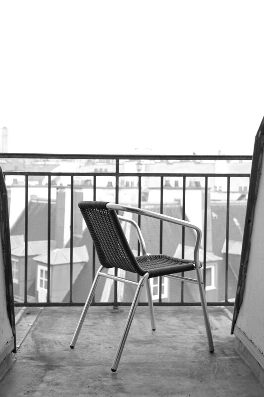Chair on a balcony overlooking rooftops