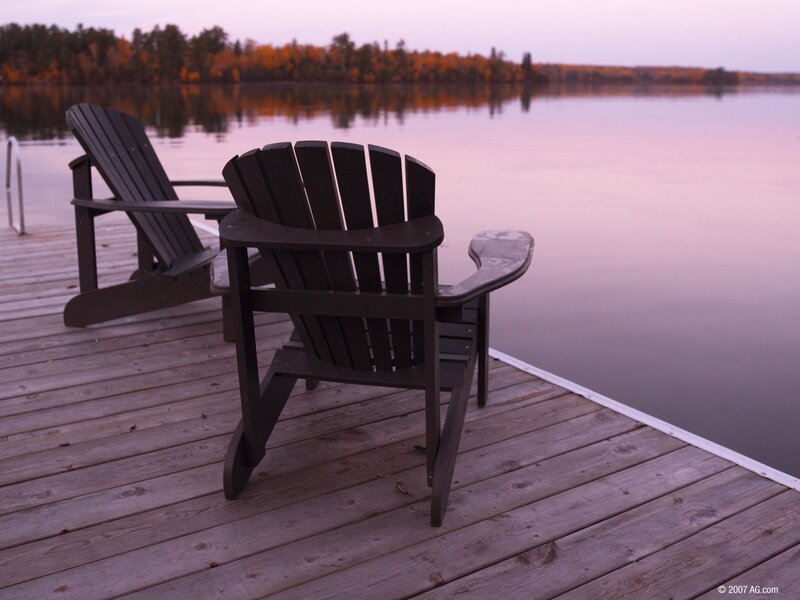 Chairs on a lake dock at dusk
